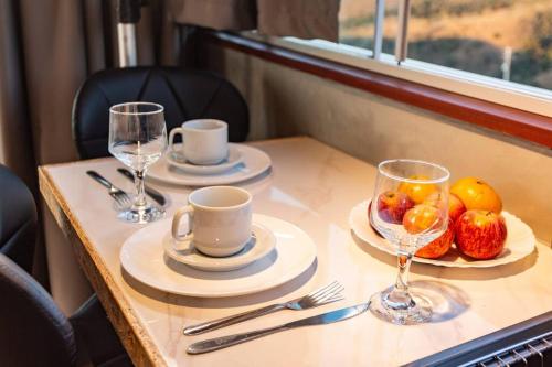 a table with two cups and a bowl of fruit at Cabana panorâmica in Cunha