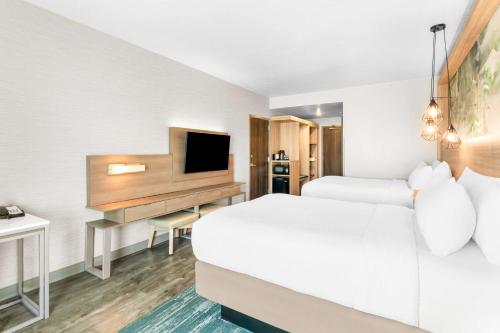 a hotel room with two beds and a desk with a television at Best Western Plus Settlers Point in Washington