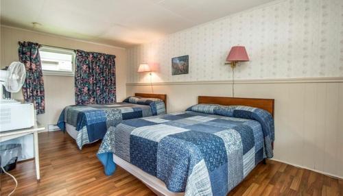 a hotel room with two beds and a window at Regent Motel in Saint John