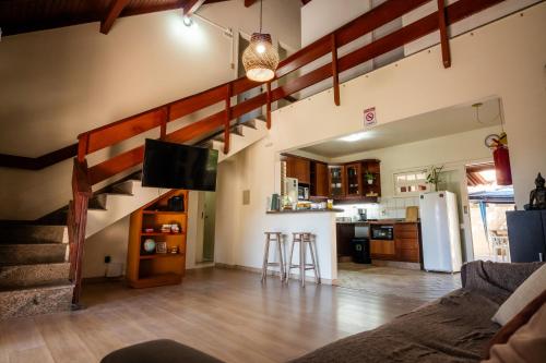 a living room with a staircase and a kitchen at Take it Easy Hostel in Florianópolis