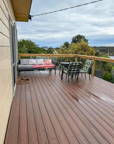 a deck with two chairs and a table on a house at Hennessy Beach House in Port Campbell