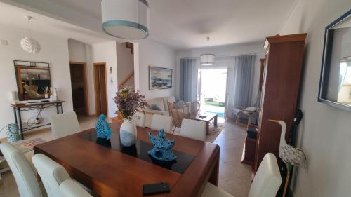 a dining room and living room with a table and chairs at Baleal Paradise Inn in Baleal