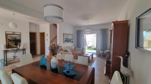 a dining room and living room with a table and chairs at Baleal Paradise Inn in Baleal
