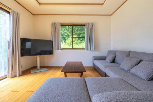 a living room with a couch and a tv at ENOKIYA Nikko in Nikko
