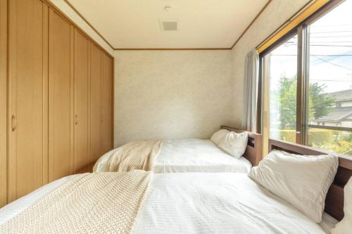 two beds in a small room with a window at ENOKIYA Nikko in Nikko