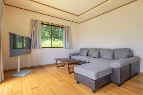 a living room with a couch and a flat screen tv at ENOKIYA Nikko in Nikko