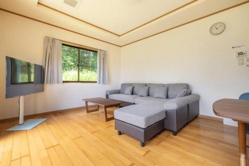 a living room with a couch and a tv at ENOKIYA Nikko in Nikko