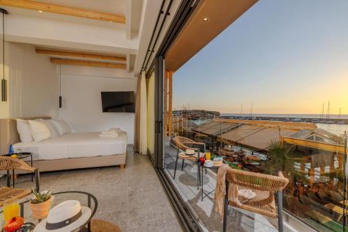 a room with a balcony with a bed and a view at Soho SeaFront Suites in Hersonissos