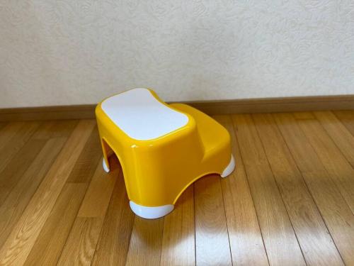 a yellow stool sitting on top of a wooden floor at ENOKIYA Nikko in Nikko