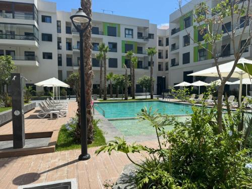 a swimming pool in front of a building at Résidence Natura Living au parc in Mohammedia