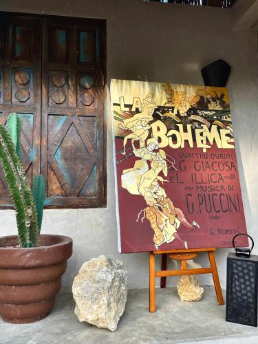 a sign on a wall next to a plant at La Bohème Boutique Glamping in General Luna