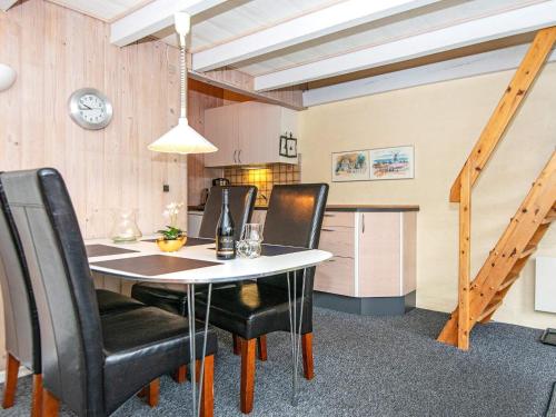 a dining room with a table and black chairs at 6 person holiday home on a holiday park in Hemmet in Hemmet