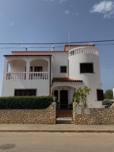 a large white house with a stone wall at Villa Carolina in Portimão
