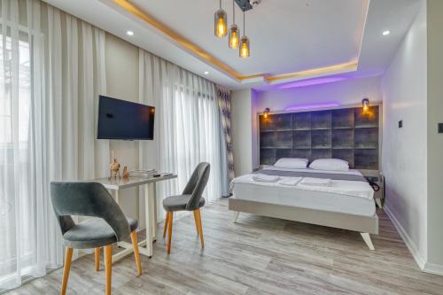 a bedroom with a bed and a desk and a tv at GALATAGREENAPPLEHOTEL in Istanbul