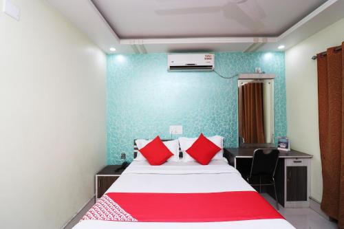 a bedroom with a bed with red pillows and a desk at Hotel O Taj Palace in Tarapith