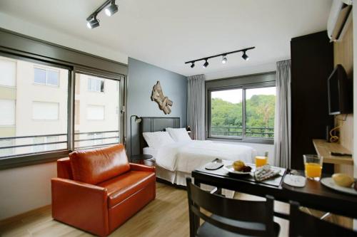 une chambre d'hôtel avec un lit, un bureau et une chaise dans l'établissement Apto frente parque com vista e piscina, à Porto Alegre