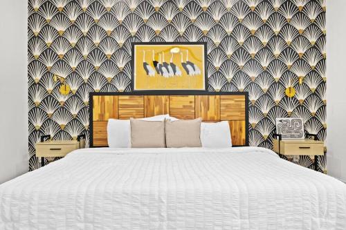 a bedroom with a white bed and a patterned wall at Downtown Luxe Retreat - King Bed, Pool, Pong, Billiards, Grill & FREE Coffee in Houston
