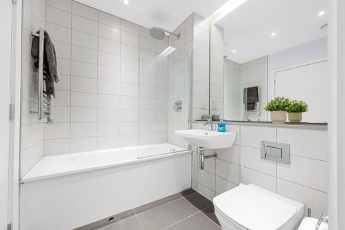 Un baño blanco con bañera, inodoro y lavabo. en Modern Apartment Central Manchester, en Mánchester