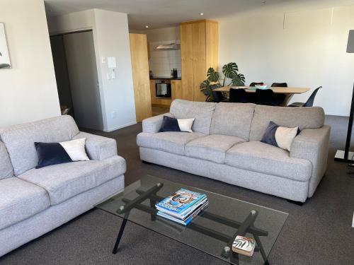 a living room with two couches and a table at Apartment in the heart of the city in Christchurch