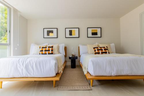 two beds sitting next to each other in a room at Capitalia Parque Lincoln in Mexico City