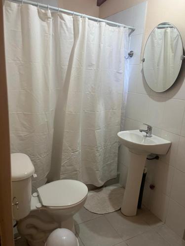 a bathroom with a toilet and a sink and a mirror at Room Estrella Ancestral in San Pedro de Atacama