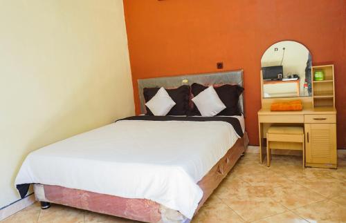 a bedroom with a large bed and a mirror at New Bintang By Four-G in Bajawa