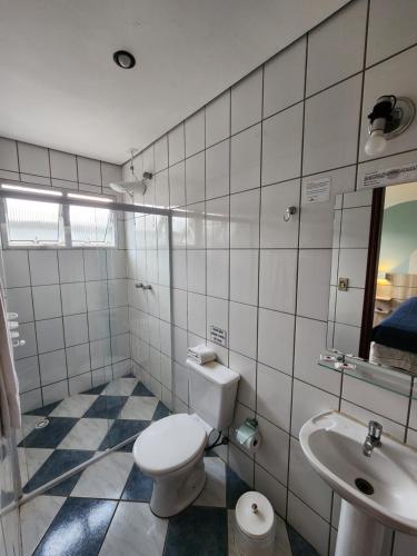 a bathroom with a toilet and a sink at Pousada Tokyo Plaza in Mogi das Cruzes