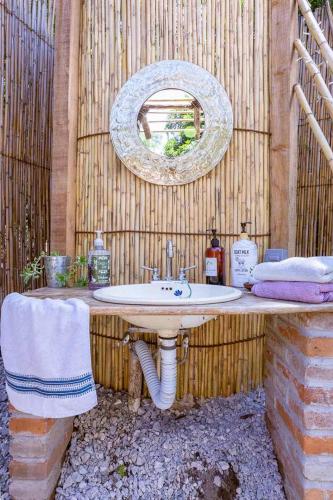 a bathroom with a sink and a mirror on a wall at New Natural Paradise Amazing Pet Friendly Cabin in Xoxocotla