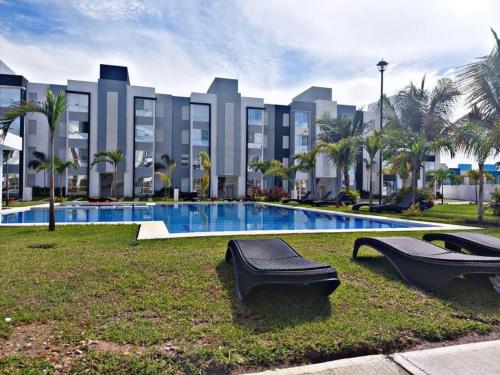 a large building with a swimming pool in a park at Bonito departamento planta baja en zona diamante in Barra Vieja
