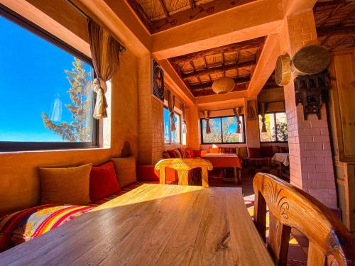 a dining room with a wooden table and chairs at Auberge Ayouze in Aït Ben Haddou