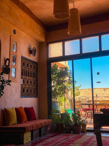 a living room with a couch and a large window at Auberge Ayouze in Aït Ben Haddou