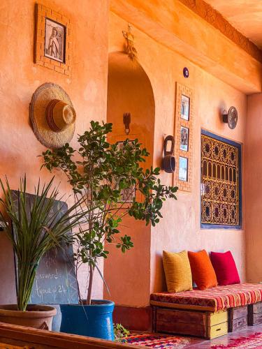 a living room with a couch and some plants at Auberge Ayouze in Aït Ben Haddou