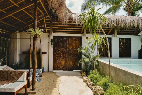 a house with a large wooden door and a swimming pool at La Bohème Boutique Glamping in General Luna