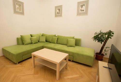 a green couch in a living room with a table at Greg Apartments Kampa Prague in Prague