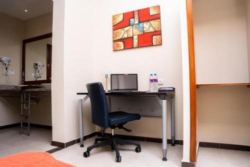 a desk with a chair and a computer on a wall at HM International Hotel in Guayaquil