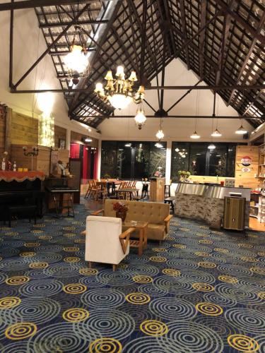 a lobby with couches and chairs on a blue and yellow carpet at Smiling Pine Dalat in Ấp Man Ling