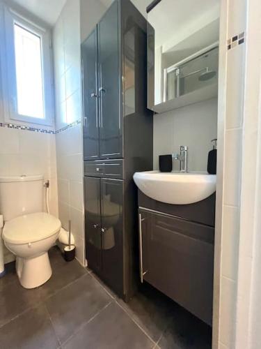une salle de bain avec des toilettes blanches et un lavabo dans l'établissement Studio confortable proche Paris, à Châtillon