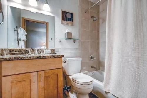 a bathroom with a toilet and a sink and a tub at Ski In, Ski Out 2 Bedroom Vacation Rental In The Heart Of Lionshead Village With Heated Slope Side Pool And Hot Tub in Vail