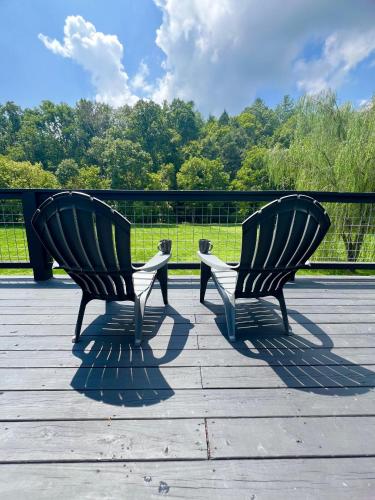 two chairs sitting on top of a wooden deck at Firefly Fields 2-Acres With Guest House, Game Room, Mountain & River Views in Sevierville