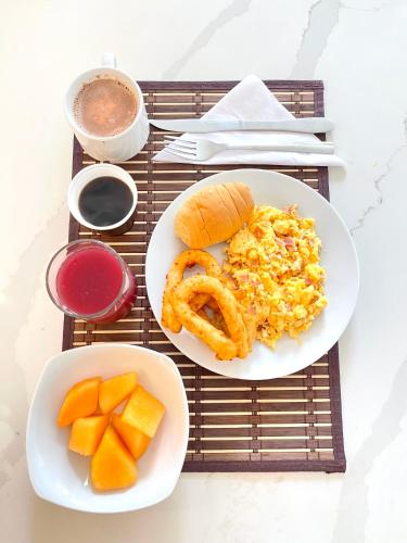 a tray with two plates of food and a plate of onion rings and a bowl at Hotel Olam Deluxe Valledupar in Valledupar