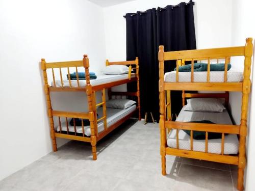 Zimmer mit 2 Etagenbetten und einem schwarzen Vorhang in der Unterkunft Ferdin Hostel e Pousada in Joinville