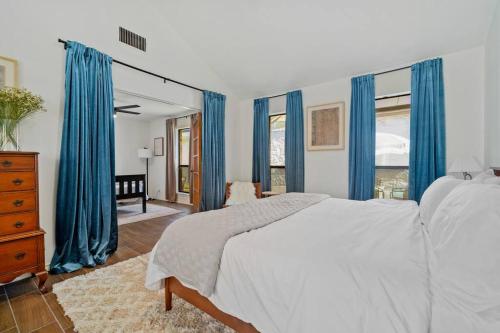 サンアントニオにあるCharming Home Near Sea World & Six Flags Sleeps 8のベッドルーム(青いカーテン、白いベッド付)
