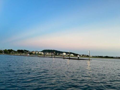 a pier in the middle of a body of water at 砂浜まで10秒 海と桟橋を一望できるHaraoka House in Minamiboso