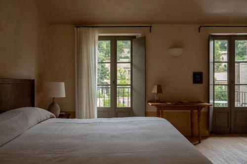 a bedroom with a large bed and two windows at Hôtel du Couvent, a Luxury Collection Hotel, Nice in Nice
