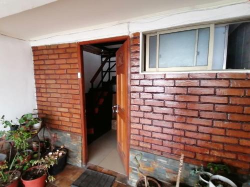 an open door to a brick house with plants at Luz House in Arica