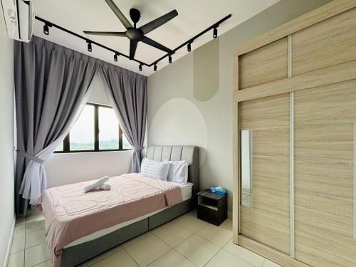une chambre avec un lit et un ventilateur de plafond dans l'établissement Youth City Residence Nilai, à Nilai