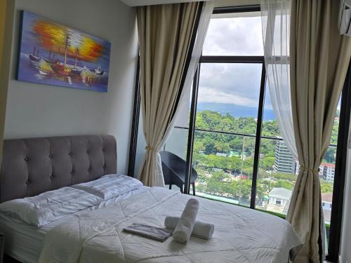 a bedroom with a bed and a large window at The Shore Home Suites Kota Kinabalu City Sabah Center in Kota Kinabalu