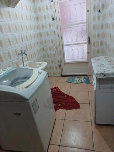 ein Bad mit einem Waschbecken und Fliesenboden in der Unterkunft CASA ALOJAMENTO EMPRESAS ou GRUPO ÚNICO in Porto Alegre