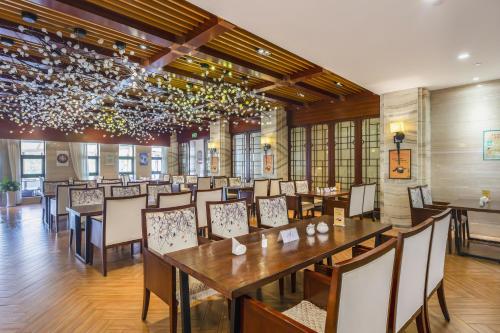 a dining room with a long table and chairs at Dengfeng Zhongzhou Huading Hotel in Dengfeng