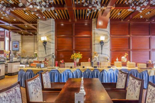 a restaurant with a long table and chairs in it at Dengfeng Zhongzhou Huading Hotel in Dengfeng